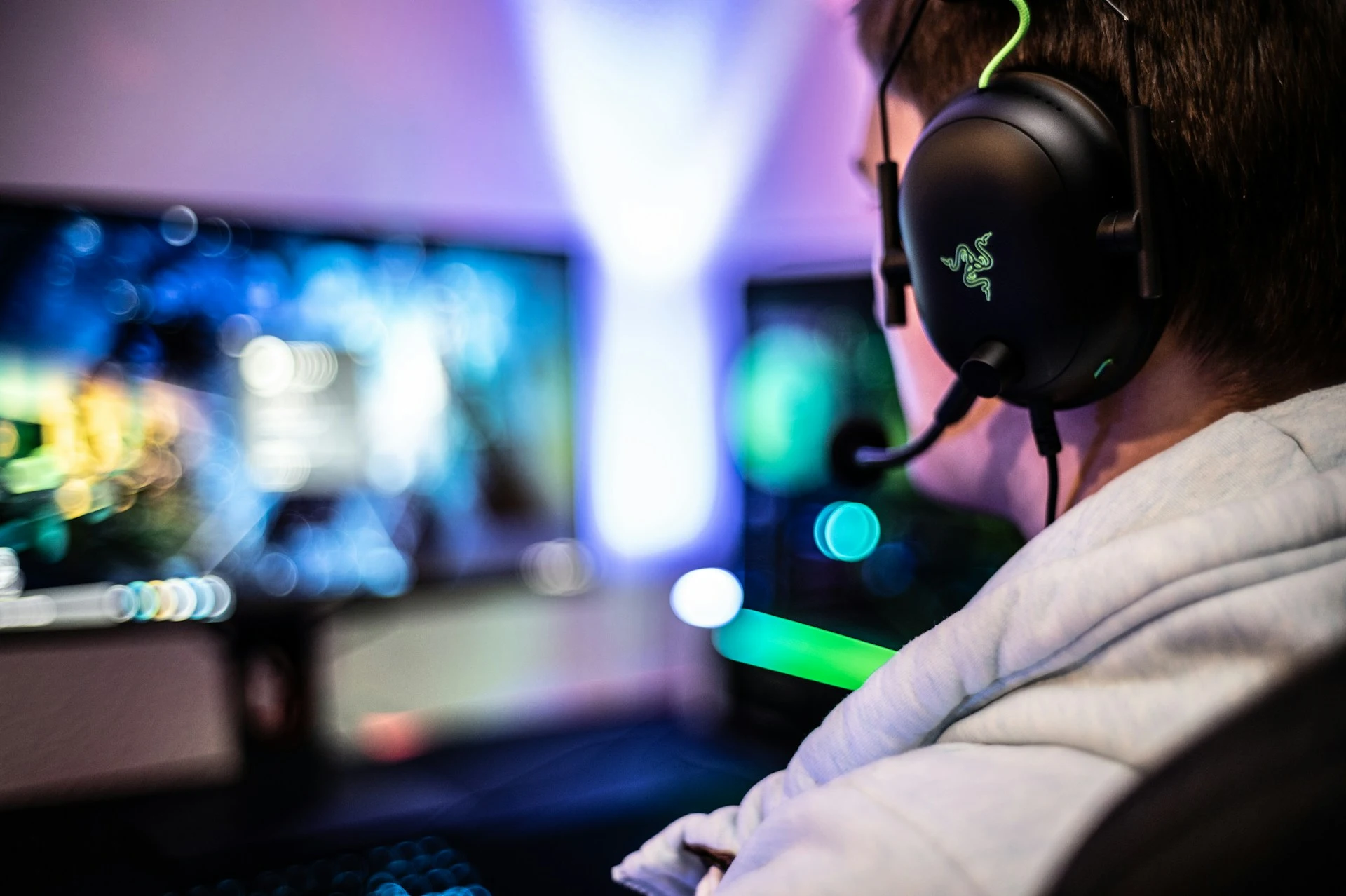 Gamer with headset lit by screen.